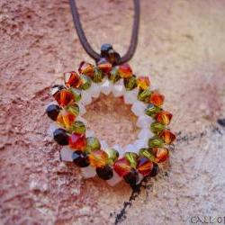 Beadwoven round pendant tangerine green burgundy white swarovski crystals. Tribal influence.